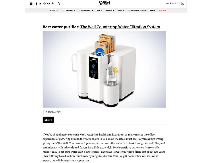 White countertop water filtration system with packaging on a white background